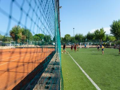 Campo da tennis e calcio con persone che giocano.