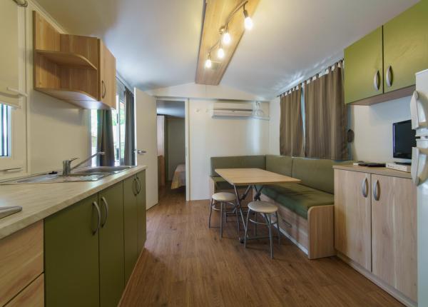 Cucina accogliente con tavolo da pranzo e divano ad angolo.