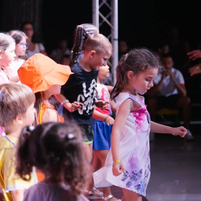Bambini che ballano insieme in una festa colorata.