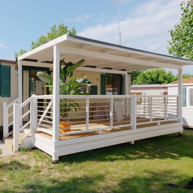 Maison mobile avec véranda et jardin, idéale pour des vacances en plein air.